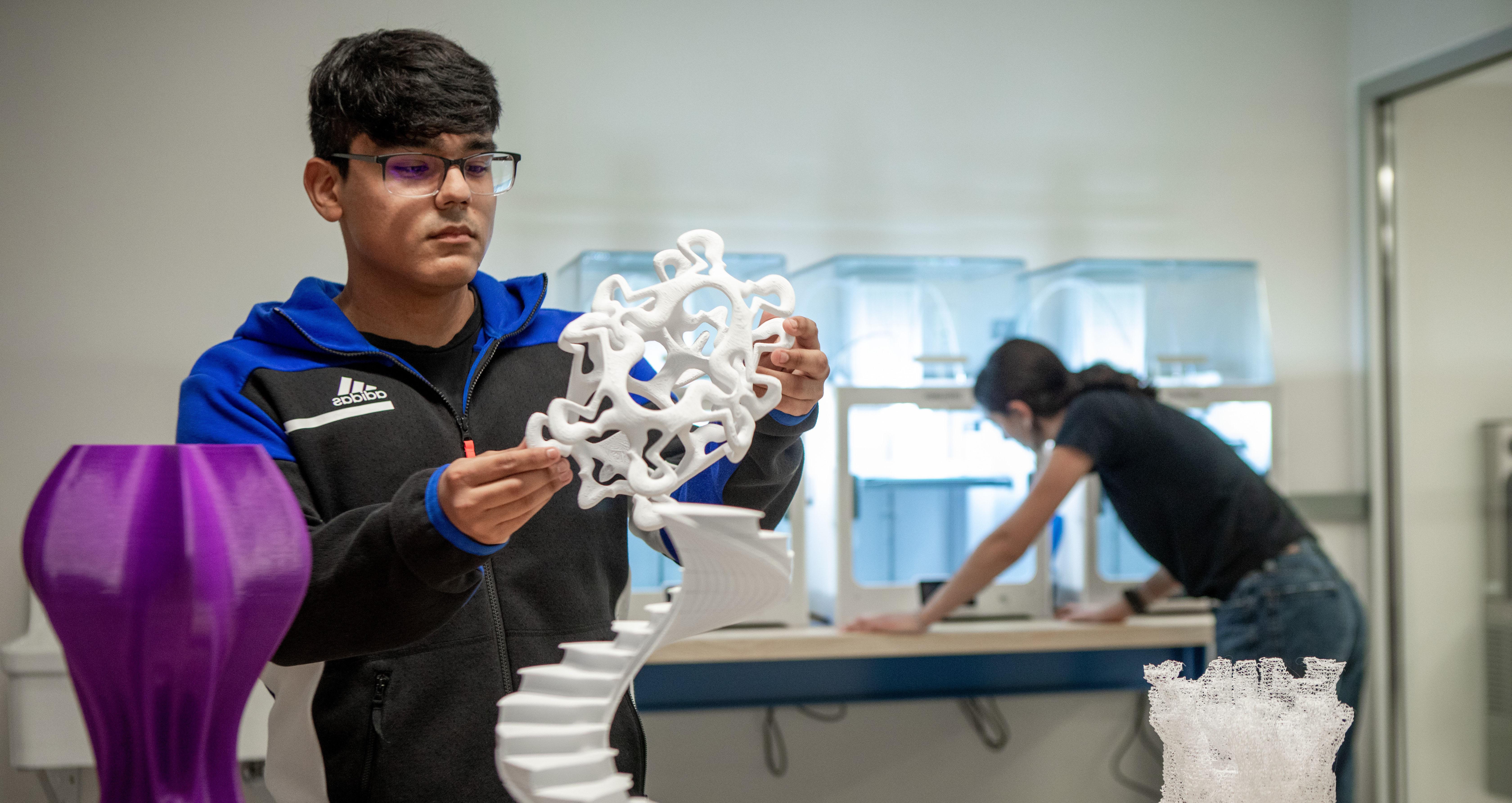 student examining sculpture in 3D printing lab